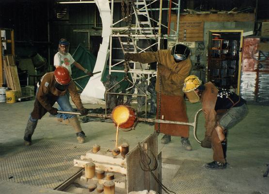 Scott Oberlink, an unidentified man, Jack Gron and Andrew Marsh pouring bronze at the University of Kentucky foundry for the casting of 