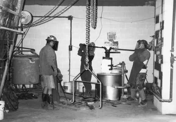 Jack Gron, Andrew Marsh and Scott Oberlink lifting the crucible for the last cast at the University of Kentucky foundry of 