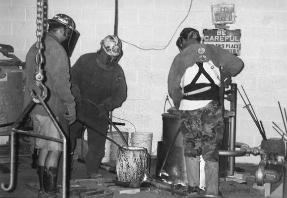 Jack Gron, Andrew Marsh and Scott Oberlink working with the crucible for the last cast at the University of Kentucky foundry of 