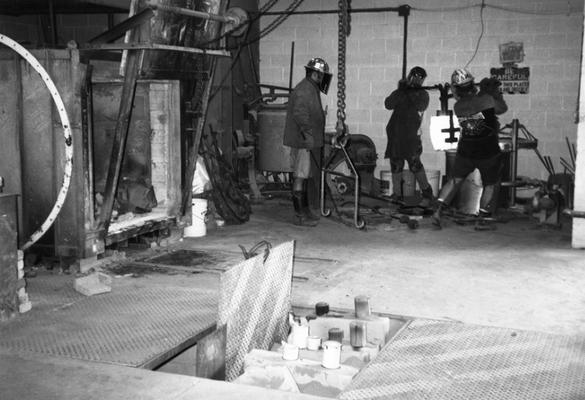 Jack Gron, Scott Oberlink and Andrew Marsh lifting the crucible for the last cast at the University of Kentucky foundry of 