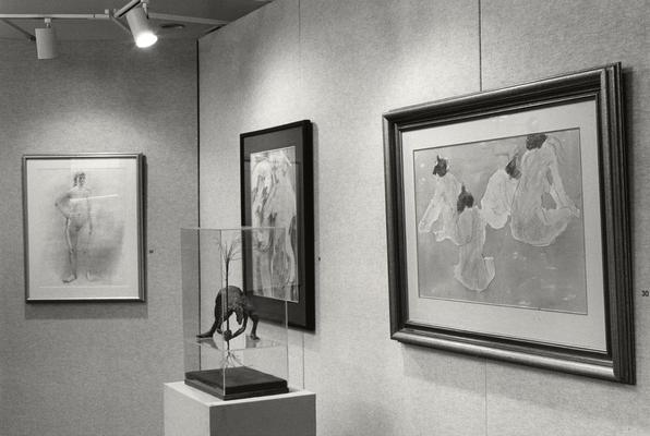 Three drawings and a bronze sculpture of human figures in an exhibit entitled 