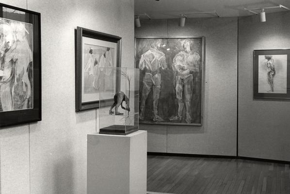 Four drawings and a sculpture of human figures in an exhibit entitled 