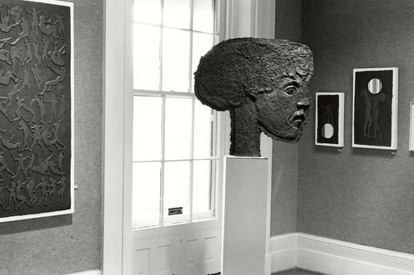 Four cast paper sculptures of human figures, one shaped as a large head, in an exhibit entitled 