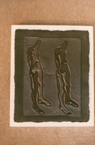 A cast paper sculpture of two human figures in an exhibit entitled 