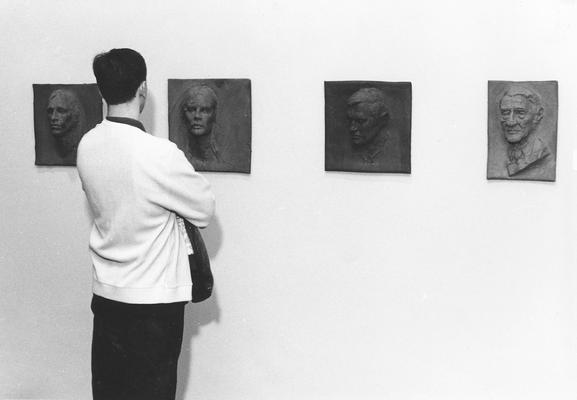 Four clay relief sculptures, the sculpture on the far right is entitled 