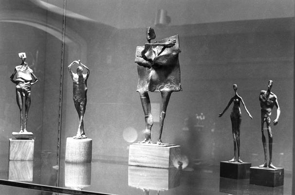 An image of five bronze figure sculptures in an exhibit case at the 