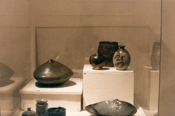 An image of several ceramic vessels in a glass case in the 
