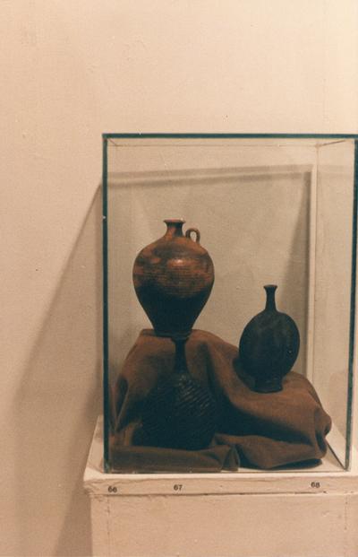 An image of three ceramic vessels in a glass case in the 