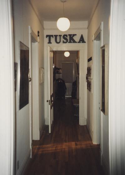 An image of a hallway hung with Tuska artwork at the opening of the Tuska Gallery, which was the home of John Tuska