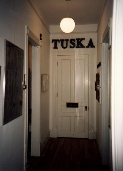 An image of a hallway hung with Tuska artwork at the opening of the Tuska Gallery, which was the home of John Tuska