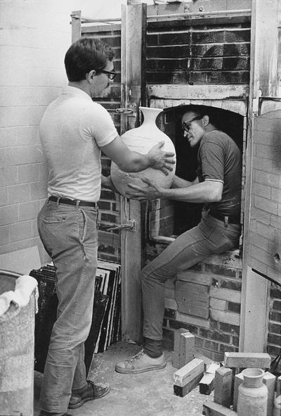An image of John Tuska and John Steenroch loading a kiln with pottery