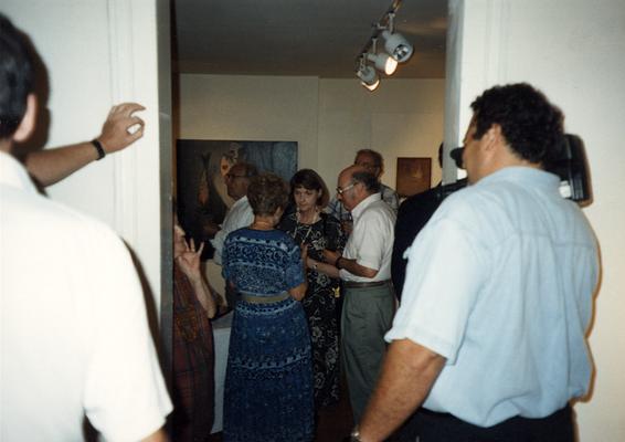 A image of Seth Tuska with a video camera and unidentified persons viewing artwork at the Heike Pickett Gallery