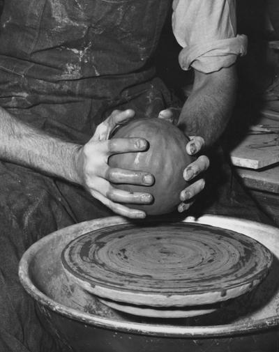 An image John Tuska preparing to throw clay on a potter's wheel for a pot