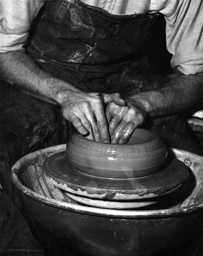 An image John Tuska shaping a clay pot on a potter's wheel