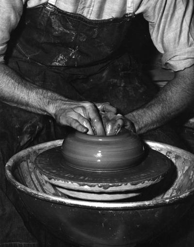 An image John Tuska forming a clay pot on a potter's wheel