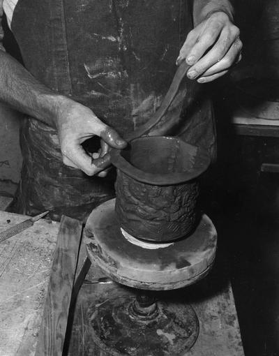 An image John Tuska putting a lip on a pot