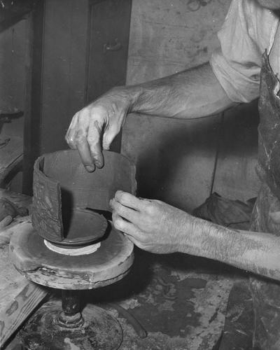 An image John Tuska attaching a textured slab on to the base of a pot