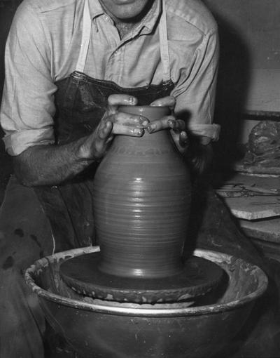 An image John Tuska forming the rim for a clay pot on a potter's wheel