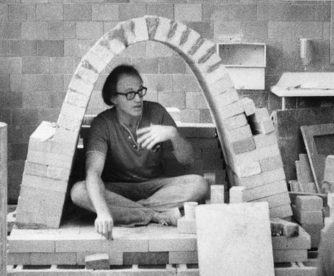 An image John Tuska sitting inside an arch kiln at the University of Kentucky art studio