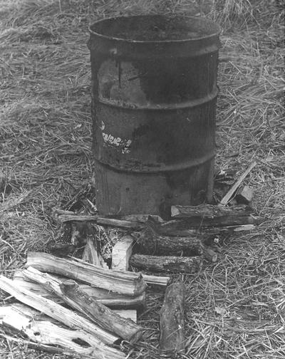 A metal barrel and wood used for raku firings