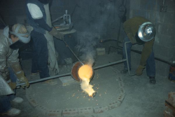 John Tuska, an unidentified person and Jack Gron finishing pouring metal in the University of Kentucky foundry. The photograph was taken by Zig Gierlach