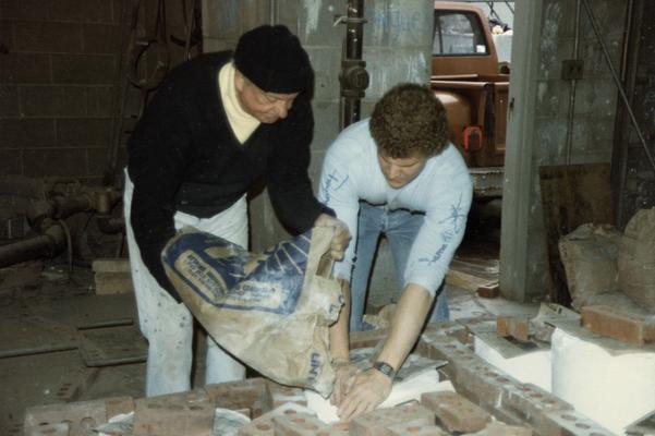 Two students preparing molds for a pour in the University of Kentucky foundry. The photograph was taken by Zig Gierlach