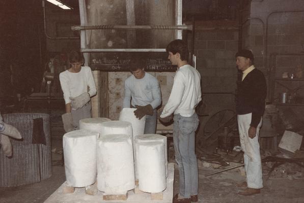 Four students moving molds in the University of Kentucky foundry. The photograph was taken by Zig Gierlach