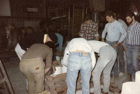 John Tuska and eight students preparing molds for a pour in the University of Kentucky foundry. The photograph was taken by Zig Gierlach