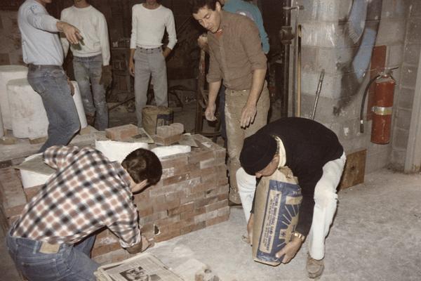 Seven students preparing molds for a pour in the University of Kentucky foundry. The photograph was taken by Zig Gierlach