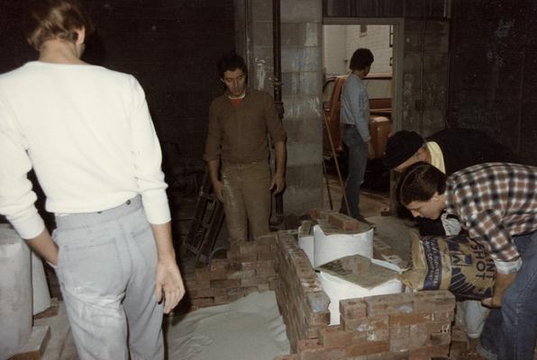 Five students preparing molds for a pour in the University of Kentucky foundry. The photograph was taken by Zig Gierlach