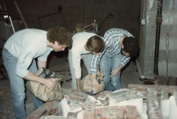 Three students preparing molds for a pour in the University of Kentucky foundry. The photograph was taken by Zig Gierlach