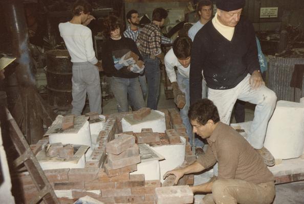 Nine students preparing molds for a pour in the University of Kentucky foundry. The photograph was taken by Zig Gierlach