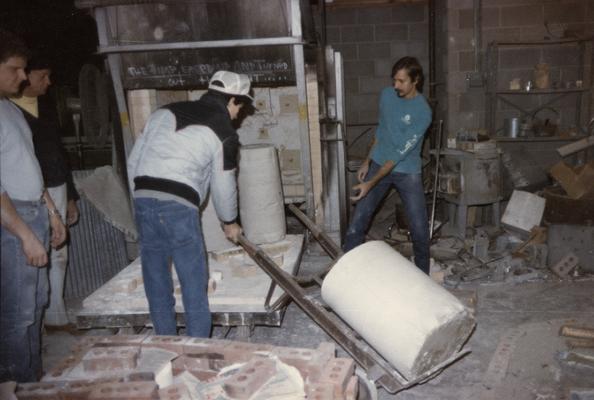 Four students moving molds in the University of Kentucky foundry. The photograph was taken by Zig Gierlach