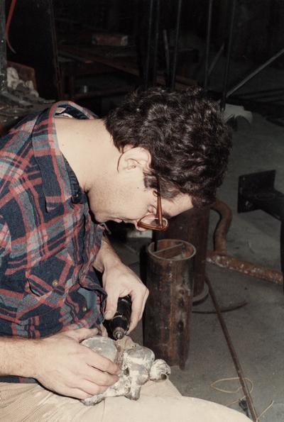 An unidentified student cutting off the spews of a sculpture in the University of Kentucky foundry. The photograph was taken by Zig Gierlach