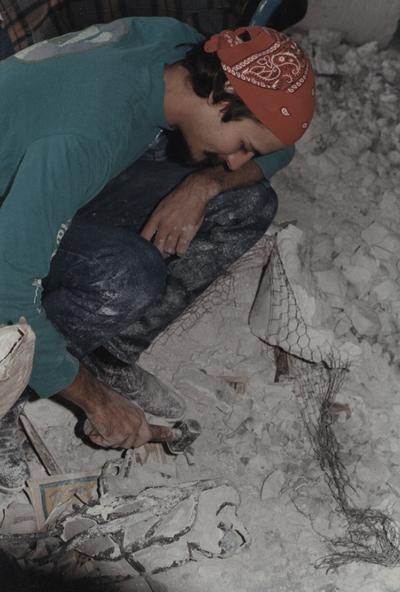 An unidentified student breaking apart a mold in the University of Kentucky foundry. The photograph was taken by Zig Gierlach