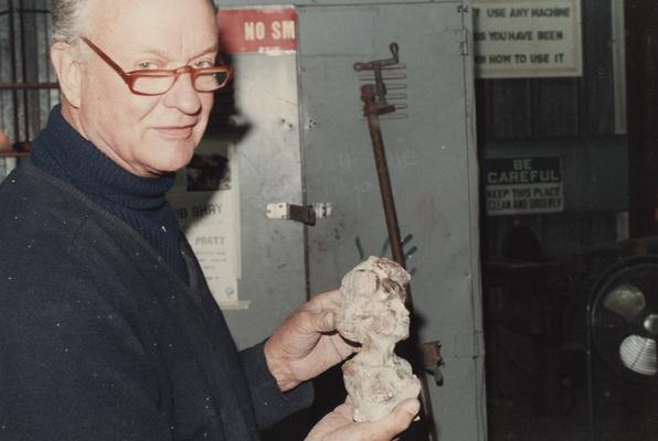 An unidentified student holding a sculpture in the University of Kentucky foundry. The photograph was taken by Zig Gierlach