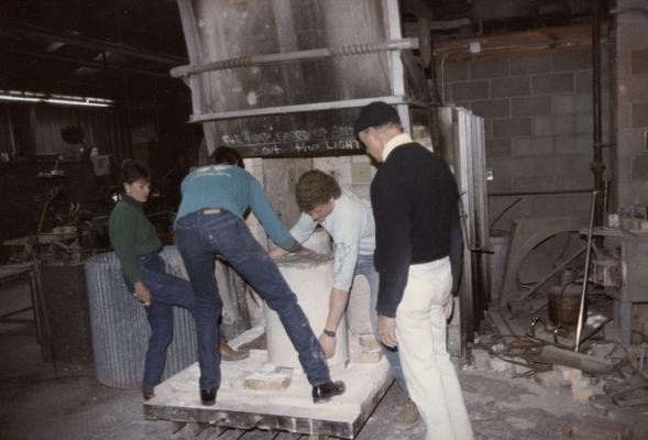 Four students moving molds in the University of Kentucky foundry. The photograph was taken by Zig Gierlach