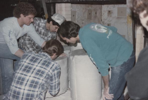 Four students moving molds in the University of Kentucky foundry. The photograph was taken by Zig Gierlach