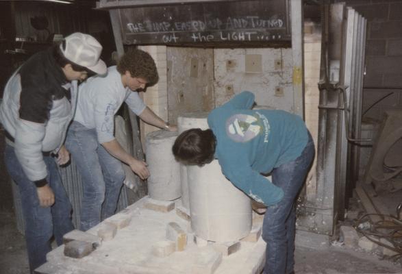 Three students moving molds in the University of Kentucky foundry. The photograph was taken by Zig Gierlach