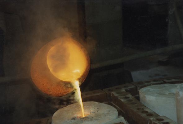 Pouring molten metal from a crucible in the University of Kentucky foundry. The photograph was taken by Zig Gierlach