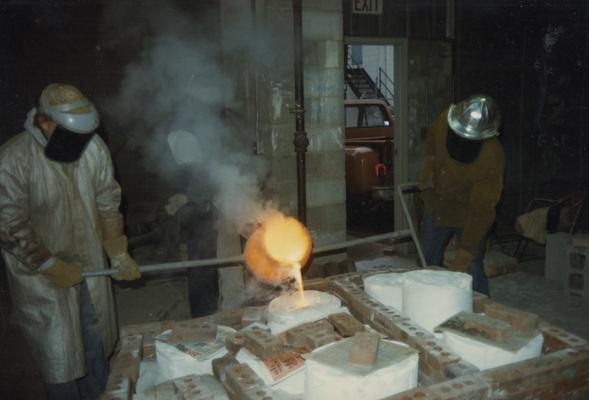 John Tuska, an unidentified student and Jack Gron pouring molten metal in the University of Kentucky foundry. The photograph was taken by Zig Gierlach