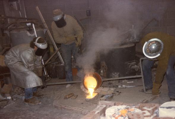 An unidentified student, John Tuska and Jack Gron pouring molten metal in the University of Kentucky foundry. The photograph was taken by Zig Gierlach