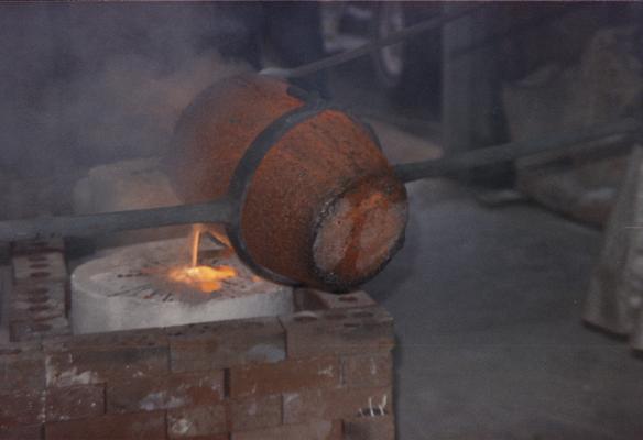 Pouring molten metal from a crucible in the University of Kentucky foundry. The photograph was taken by Zig Gierlach