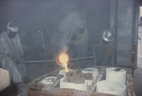 An unidentified student, John Tuska and Jack Gron pouring molten metal in the University of Kentucky foundry. The photograph was taken by Zig Gierlach