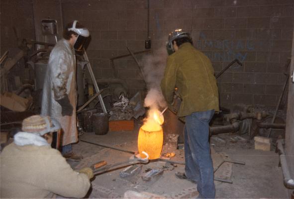 John Tuska, an unidentified student and Jack Gron preparing to pour molten metal into a mold in the University of Kentucky foundry. The photograph was taken by Zig Gierlach