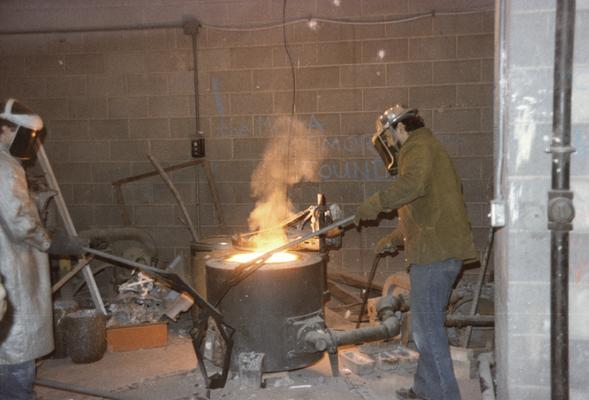 An unidentified student and Jack Gron working with the furnace in the University of Kentucky foundry. The photograph was taken by Zig Gierlach