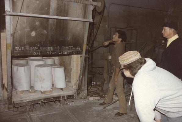 Two unidentified students and John Tuska preparing to move some molds in the University of Kentucky foundry. The photograph was taken by Zig Gierlach