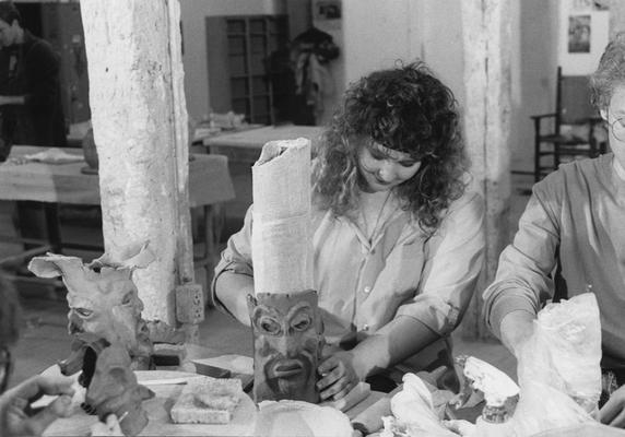 A group of several students working on clay around tables in John Tuska's ceramics class at the University of Kentucky