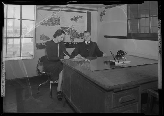 Packard Motor Cars (Vine at Southeastern Avenue) garage; interior of office; man and woman working at desk