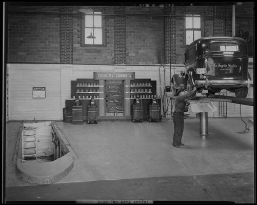 Taylor Tire Company, East Vine and Southeastern Avenue; interior; man working on Lafayette Studios vehicle; car on lift